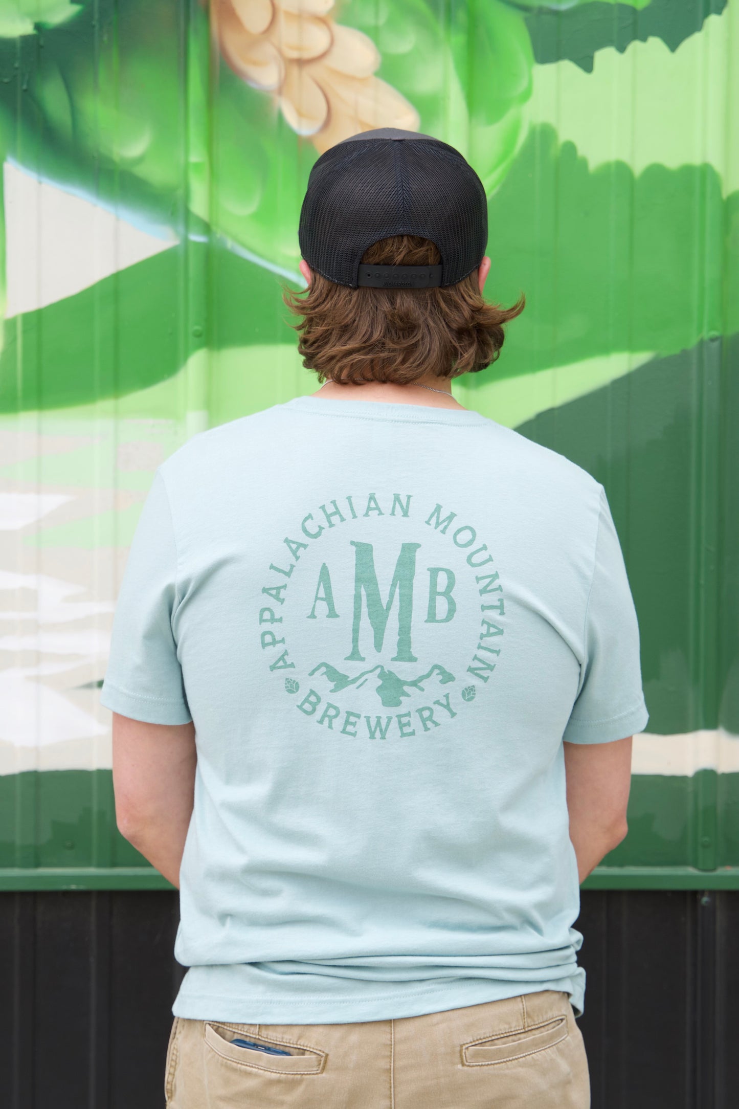 The back of the Dusty Blue AMB Logo T-shirt with AMB logo on back